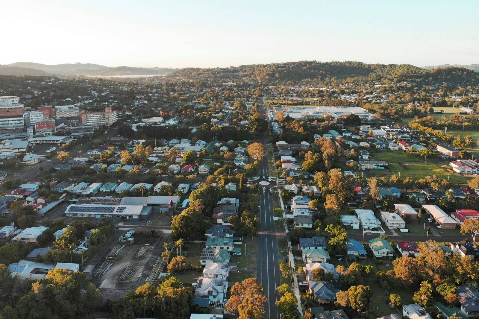 Aerial view of Lismore at sunrise, with green hills behind the town