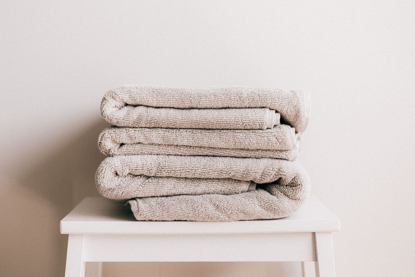 Freshly folded towels stacked on a white stool