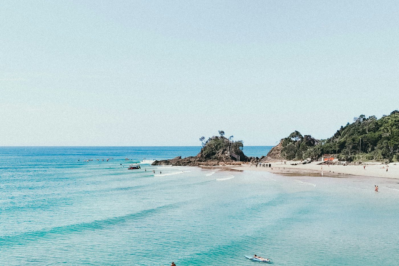 Surfers floating in clear turquoise water at The Pass, Byron Bay
